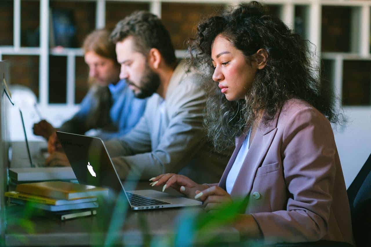 Focused colleagues working on laptops in office